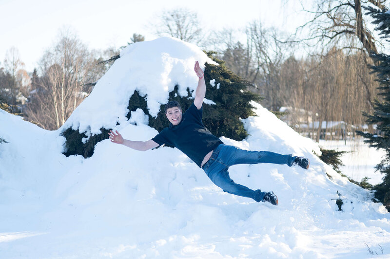Jacob jumping into a mound of snow.