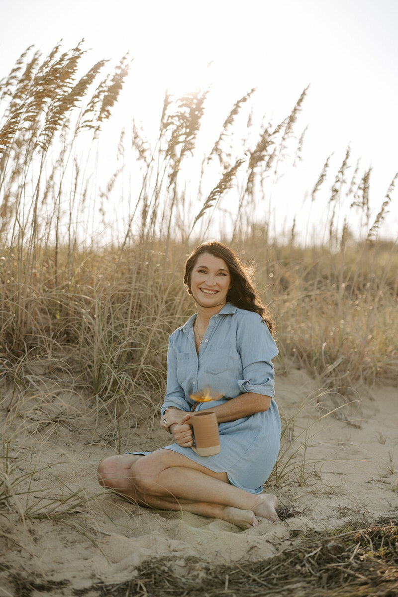 Therapist sitting on floor laughing while holding computer