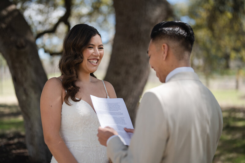 Asian bride and groom exchange wedding vows at their outdoor wedding