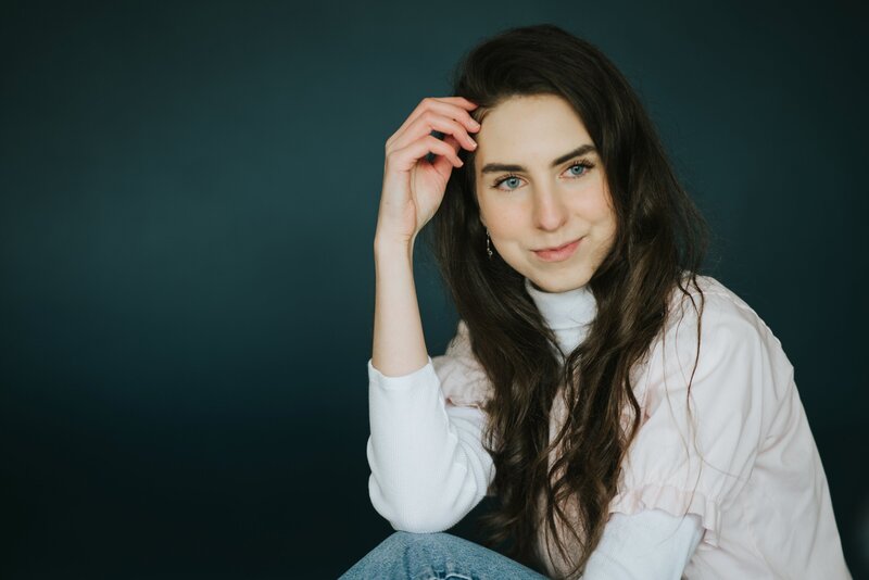 woman sits in studio with blue backdrop in knoxville tennessee