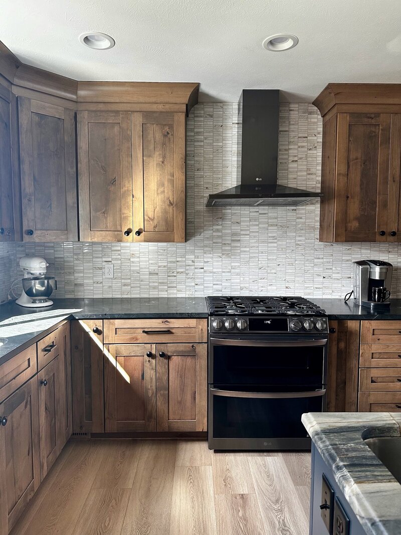 Kitchen with marble countertops, dramatic light fixtures and a deep blue island