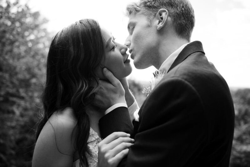 Ohio bride  in a white wedding dress and groom in a black tux, embrace and start to kiss in Cuyahoga Valley National Park on their wedding day. Photo taken by Cleveland wedding photographer Aaron Aldhizer