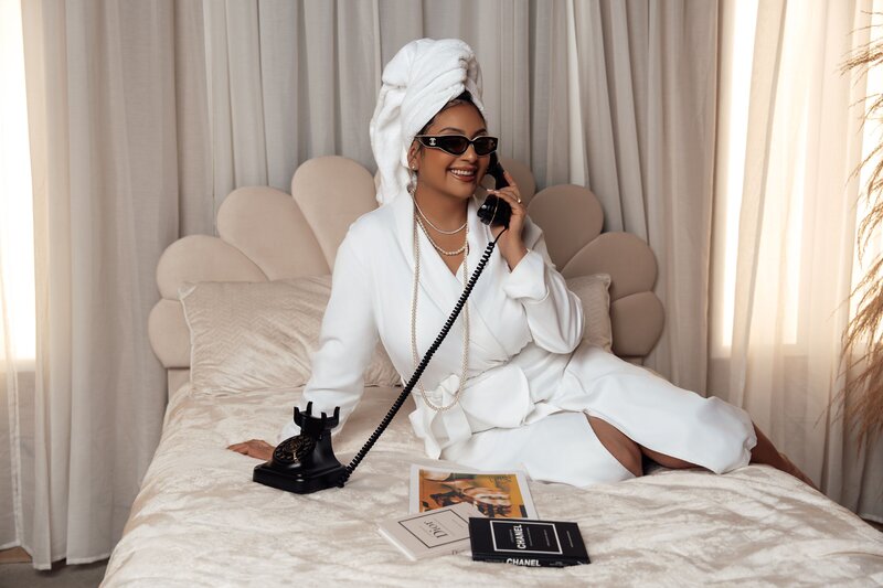 Bianca smiling talking on the phone in bed