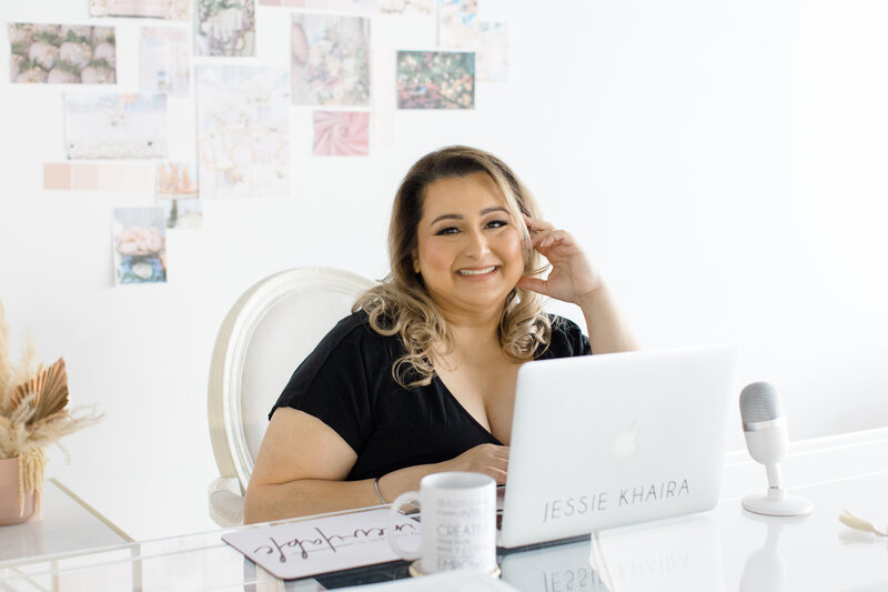 luxury sikh wedding planner smiling at her desk in front of her laptop