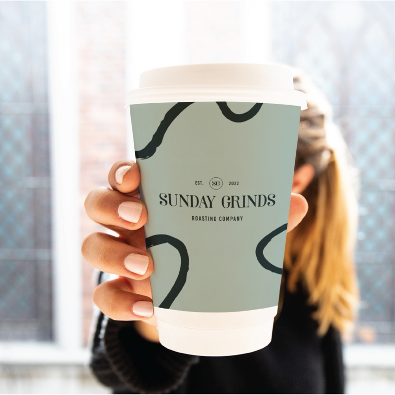 Sunday Grinds branding shown on a coffee cup held by a woman