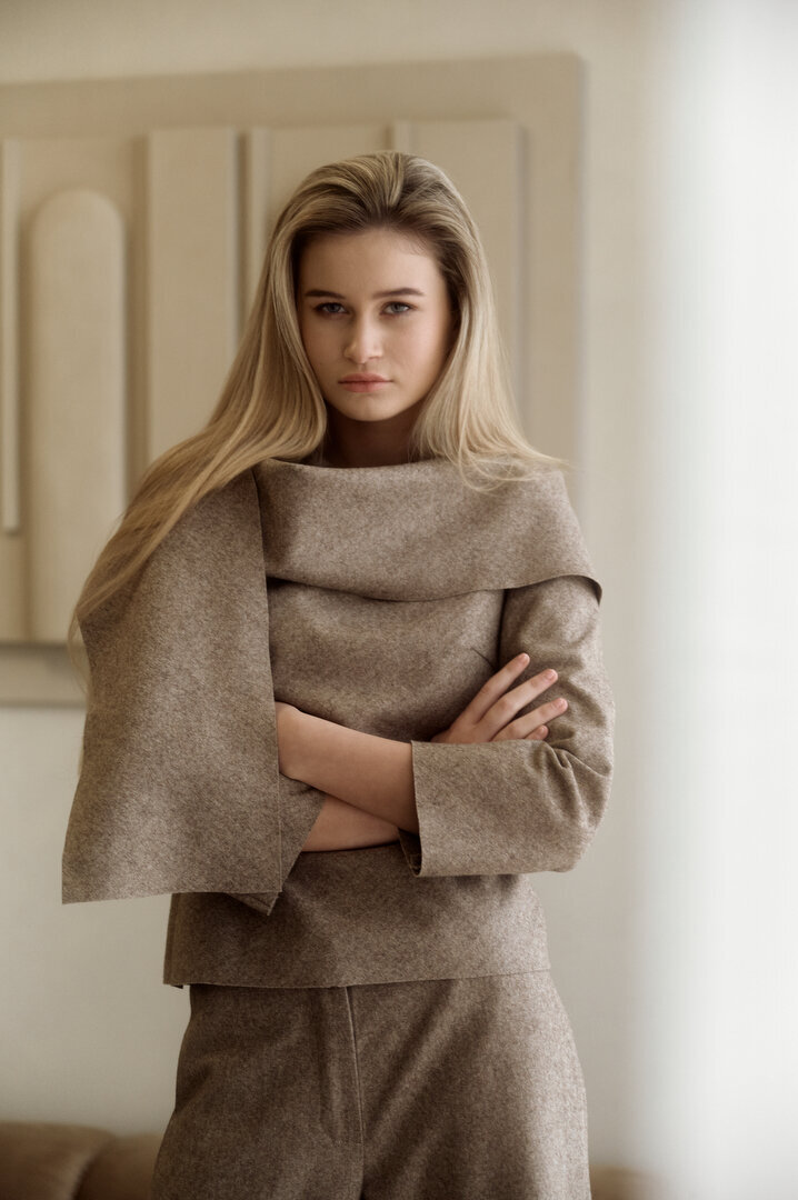 Stijlvolle dame in een witte jurk tijdens een fashion shoot, vastgelegd in een elegante setting.