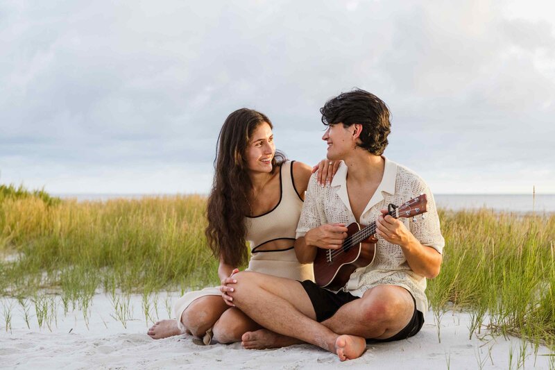 Man plays ukulele for his fiance on the beach