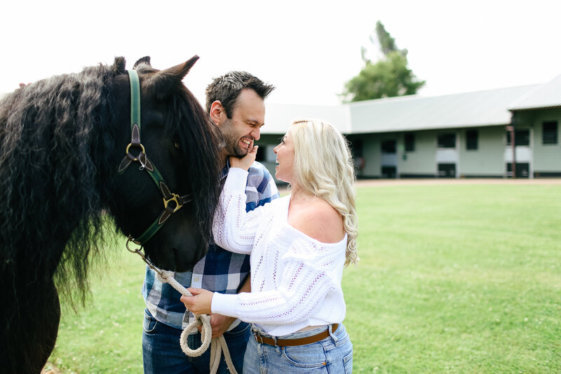 couple-smiling-with-horse-at-engagement-shoot-in-buckinghamshire-by-leslie-choucard-photography