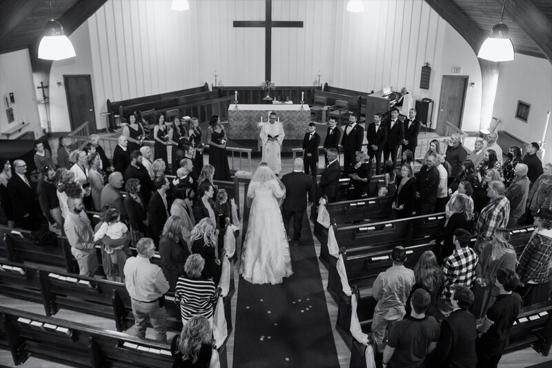 Bride and Groom facing priest at the altar | Rangeley Maine Wedding Photography