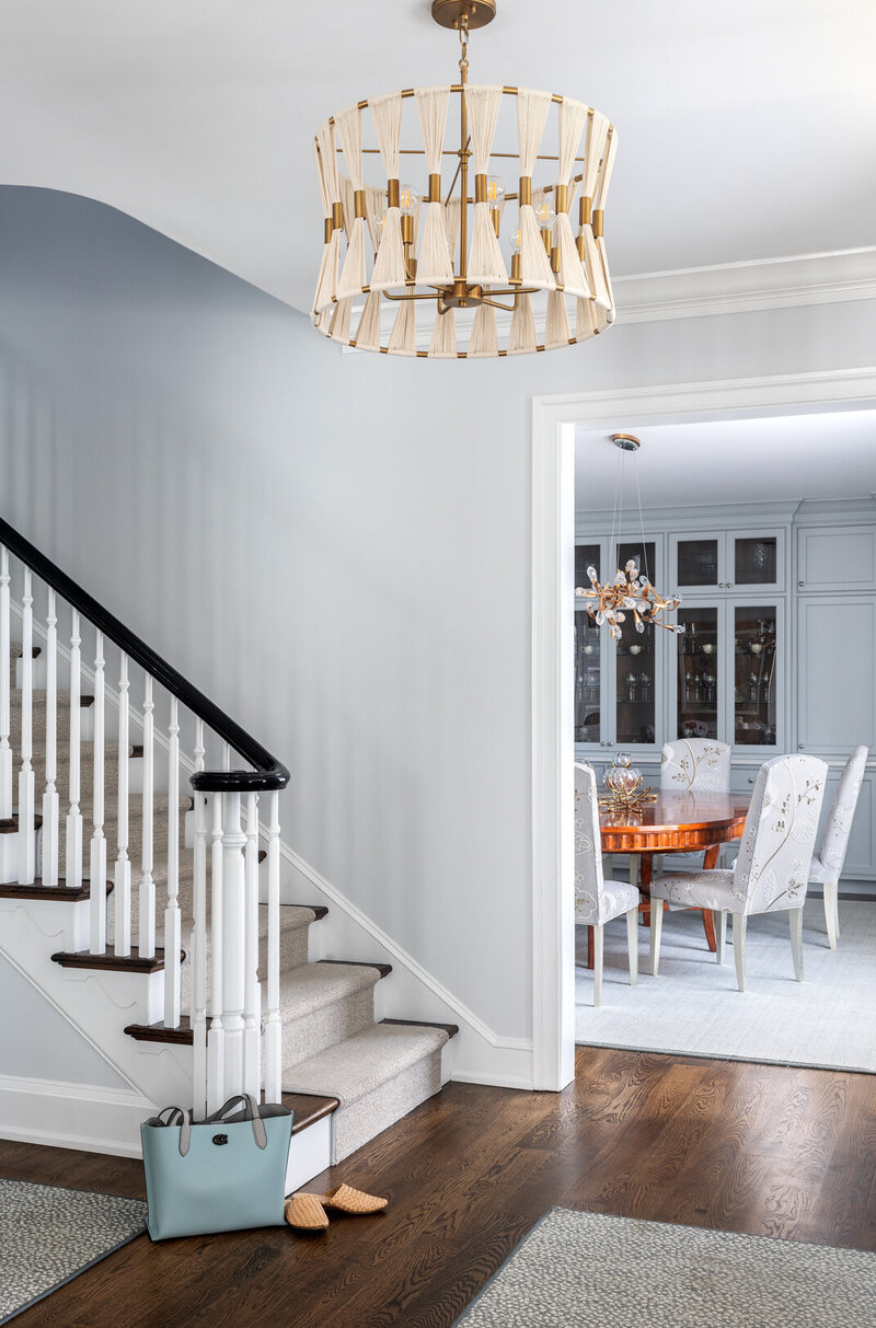 white wall entry way with chandelier and stairs looking into dining room