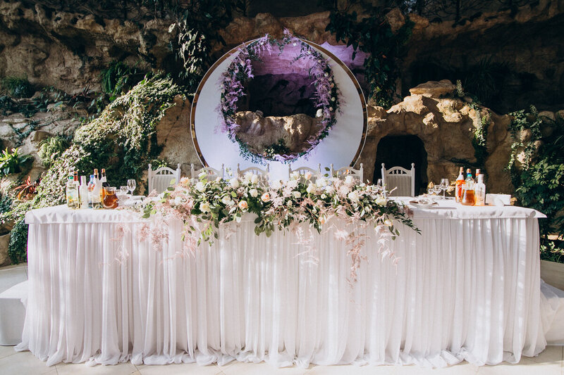 Table des mariés décorées de voilages, de végétal et surmontée d'une arche en forme de croissant de lune. Projet imaginée par une décoratrice de mariage.