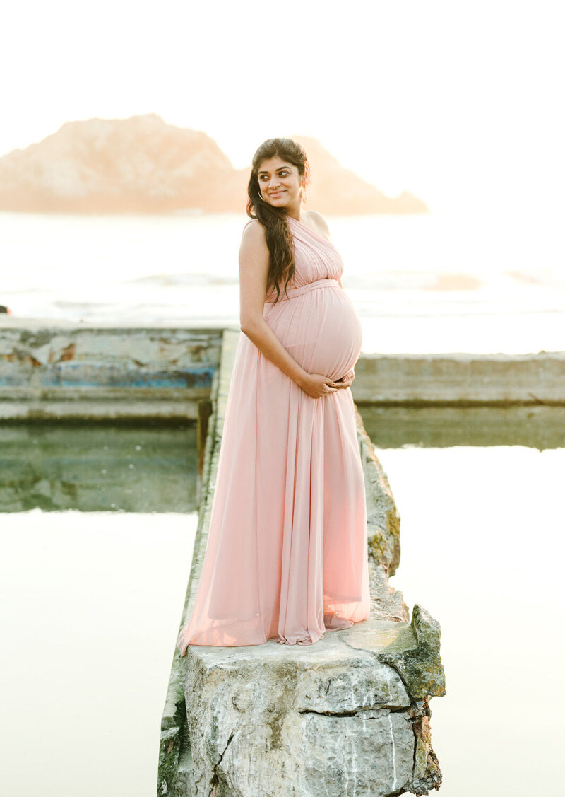 Maternity shot of a lady in pink holding her belly, Bay Area