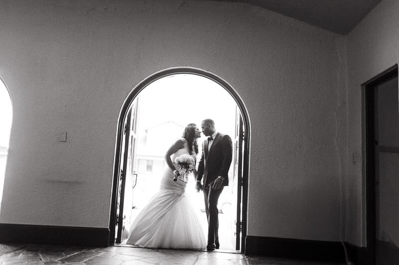 Couple embracing at a doorway to a church