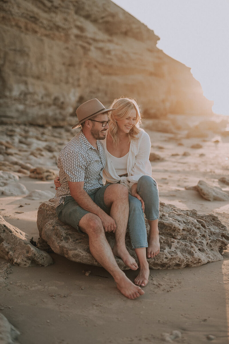 Jessie and Luke at the beach during sunset, captured during a photo session. Luke is wearing a hat.