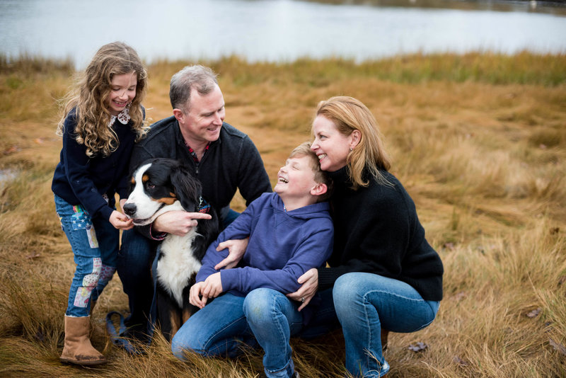 family laughing with their dog