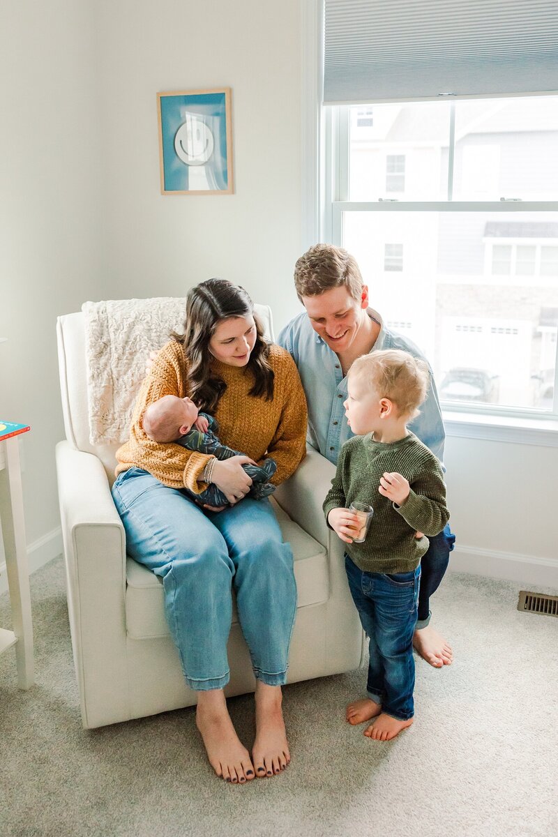 Loving parents cradling their newborn during a cozy lifestyle session in Harrisonburg, VA