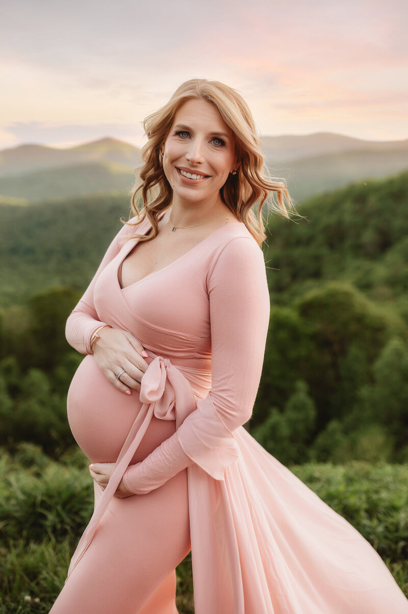 Expectant mother embraces her pregnancy belly during Maternity Photoshoot in Asheville, NC.