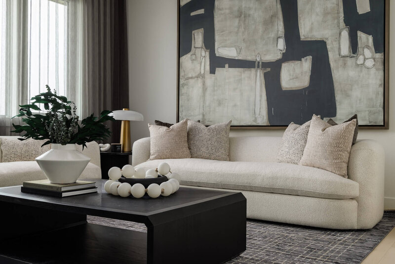 Lounge area with oversized light custom furniture and dark black accents. 