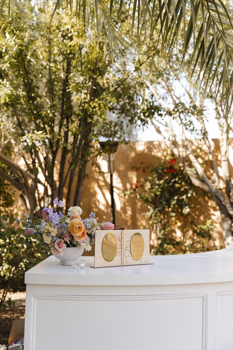 wedding bar with florals and sign