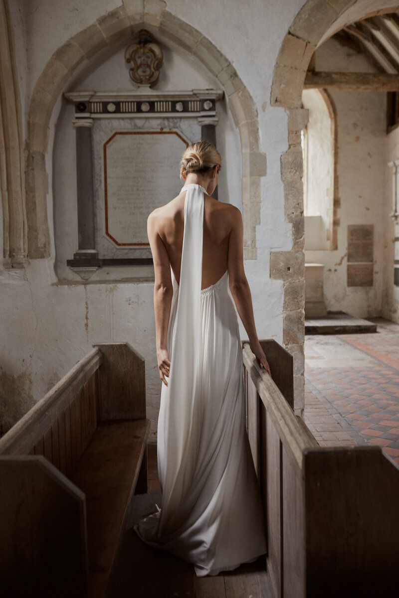 Deep v back high neck silk wedding dress on natural bride in church