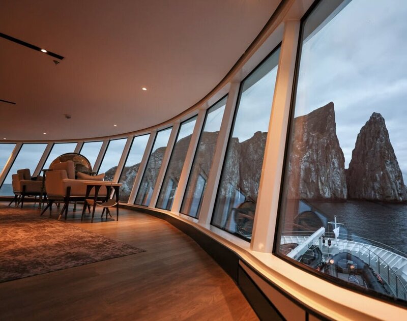 windows of a cruise ship looking out on rocks