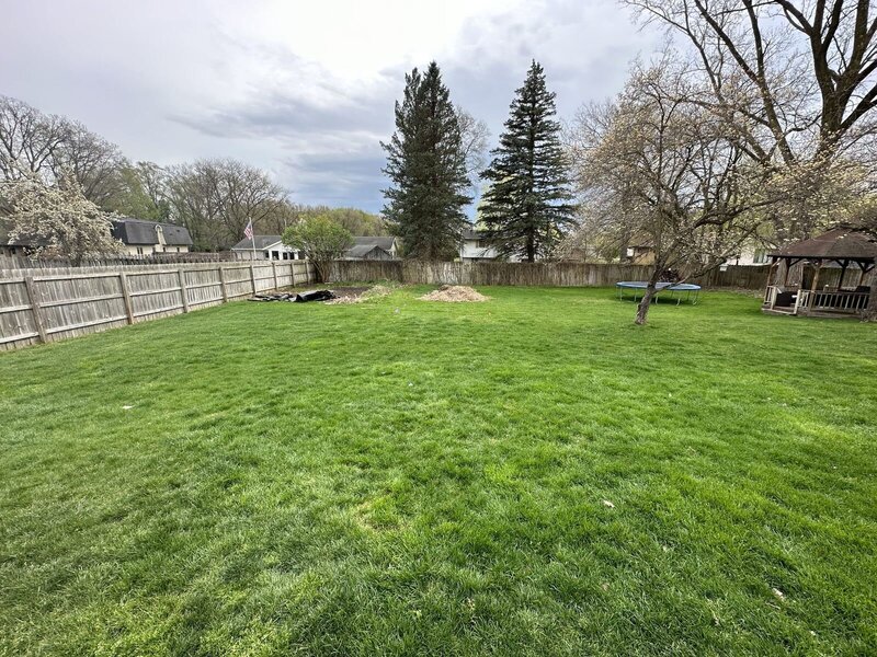 Before: open backyard lawn behind a privacy fence in Elkhart, IN
