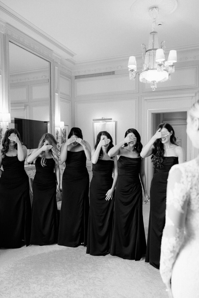 Bride revealing to her bridesmaids her laced Monique Lhuillier gown.