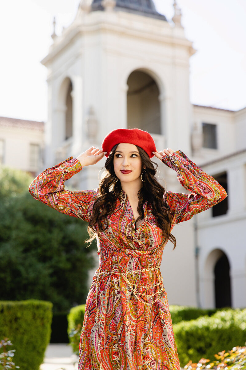 Senior girl posing in a red beret and colorful paisley dress at Pasadena City Hal