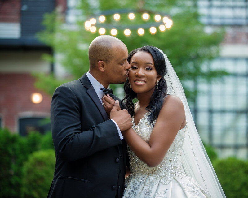Groom kissing his bride on the cheek during their wedding celebration at Cescaphe's Vie venue in Philadelphia.