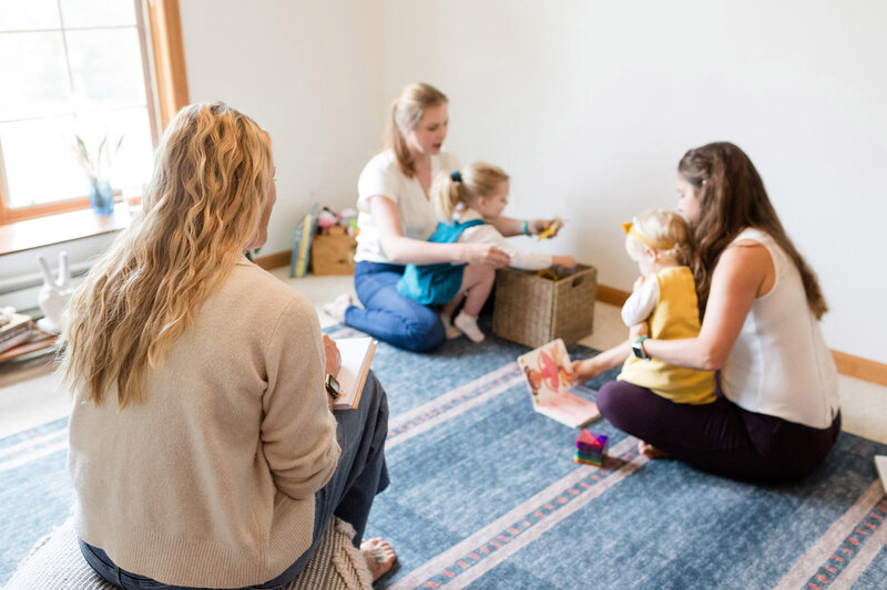 Parent coach Amy Fink observing two parents as their toddlers play