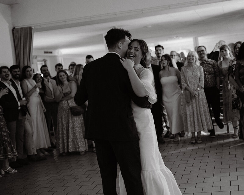 Husband and wife seal the deal with their first kiss amongst a backdrop of greenery