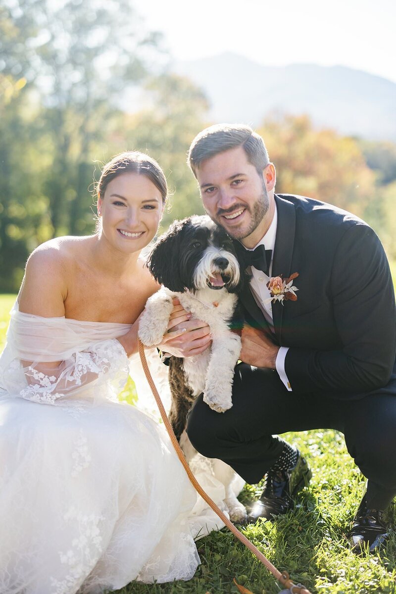 Bride and groom take wedding portrait with their dog