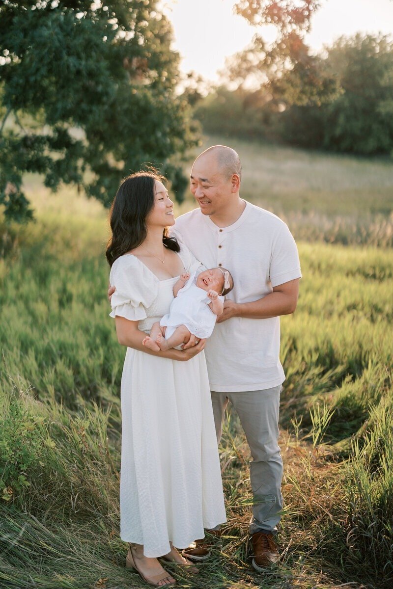 A couple holding their new baby, captured by Emily Barbara, a family photographer in Milwaukee.