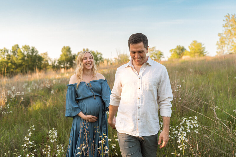 pregnant lady standing on a cliff at sunset