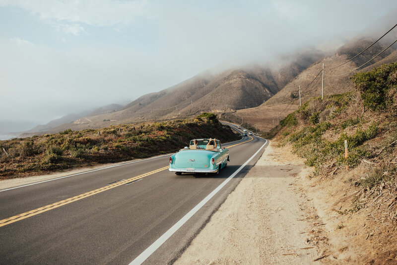 bride and groom driving down coastal highway