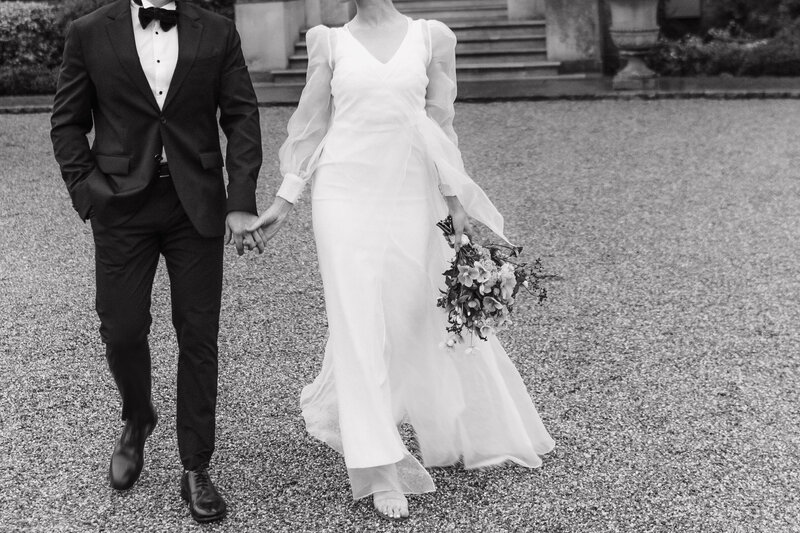 Wedding photographer captures couple taking a stroll hand in hand at their french chateau wedding.