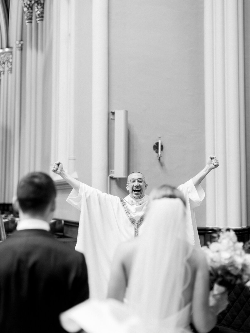 a Catholic priest cheering during a wedding ceremony