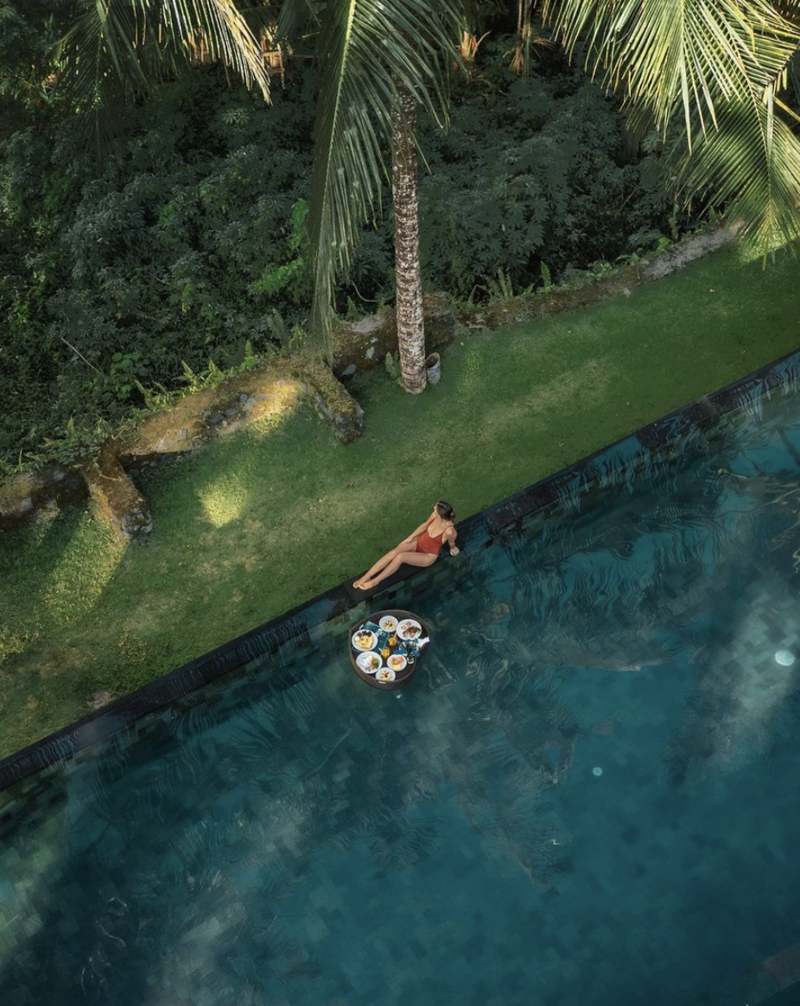 girl relaxing in a pool in bali surrounded by the jungle