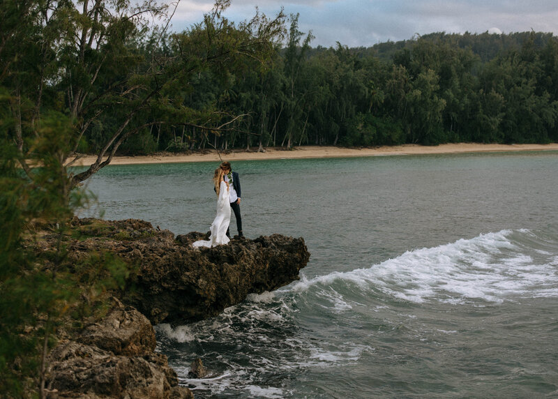bride and groom posing on shoreline