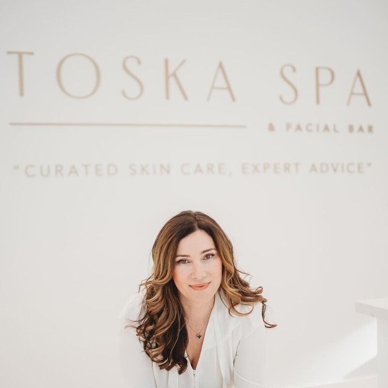 Woman with brown hair smiling at camera in luxury beauty salon brand design