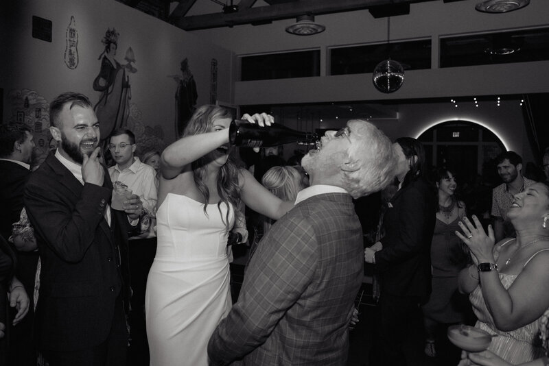The bride pouring champagne for a guest on the dance floor, documented by Photo TM (T+m Photo), a Sacramento professional photographer offering boudoir photographers near me and event photography packages.