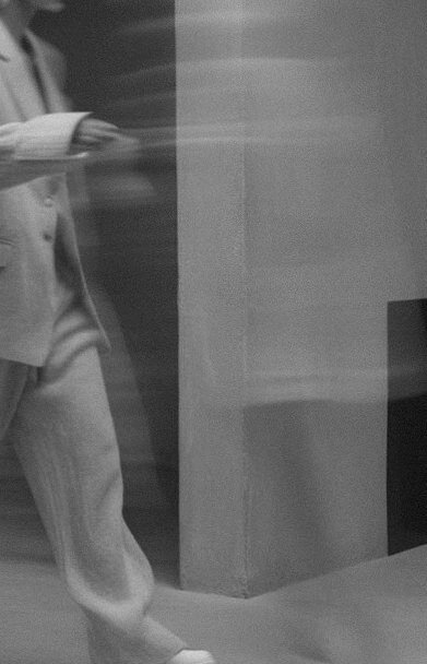 Blurred black and white image of a woman walking, symbolising movement and transformation in manifestation coaching.