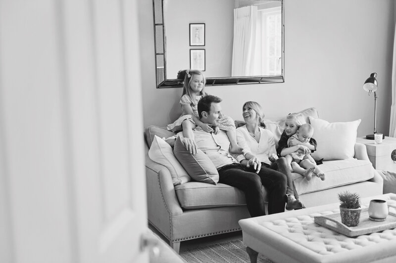 A family of 5 cuddle on the sofa during a family photo shoot