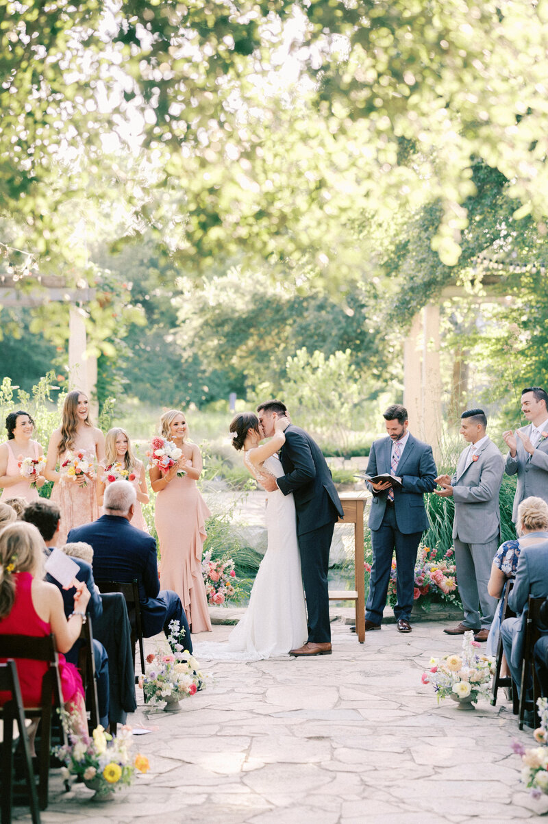 first kiss at wedding ceremony in spring at ladybird johnson wildflower center by austin wedding photographer tara paige weddings