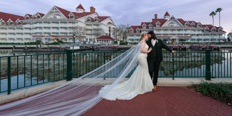 Couple enjoying a serene sunset outside the Grand Floridian Hotel, highlighting their Disney wedding day.