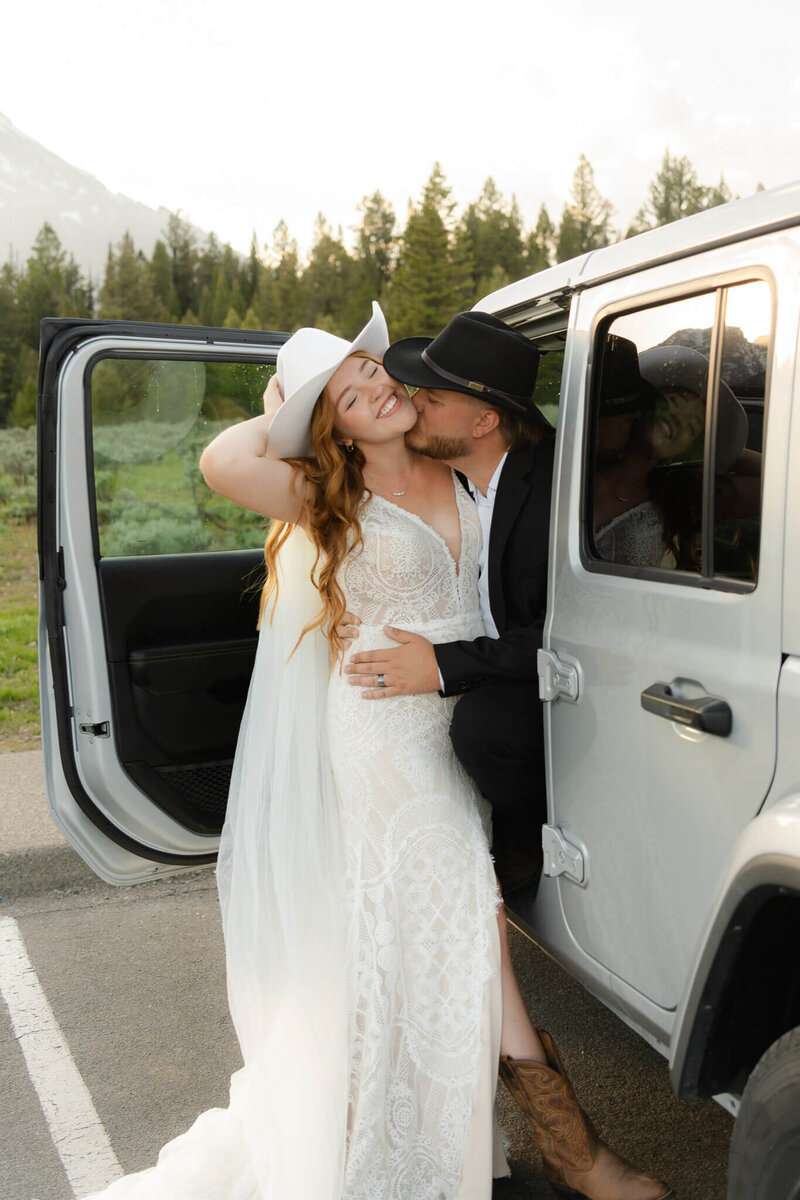 bride smiles and leans into her husband kissing her neck during their destination elopement