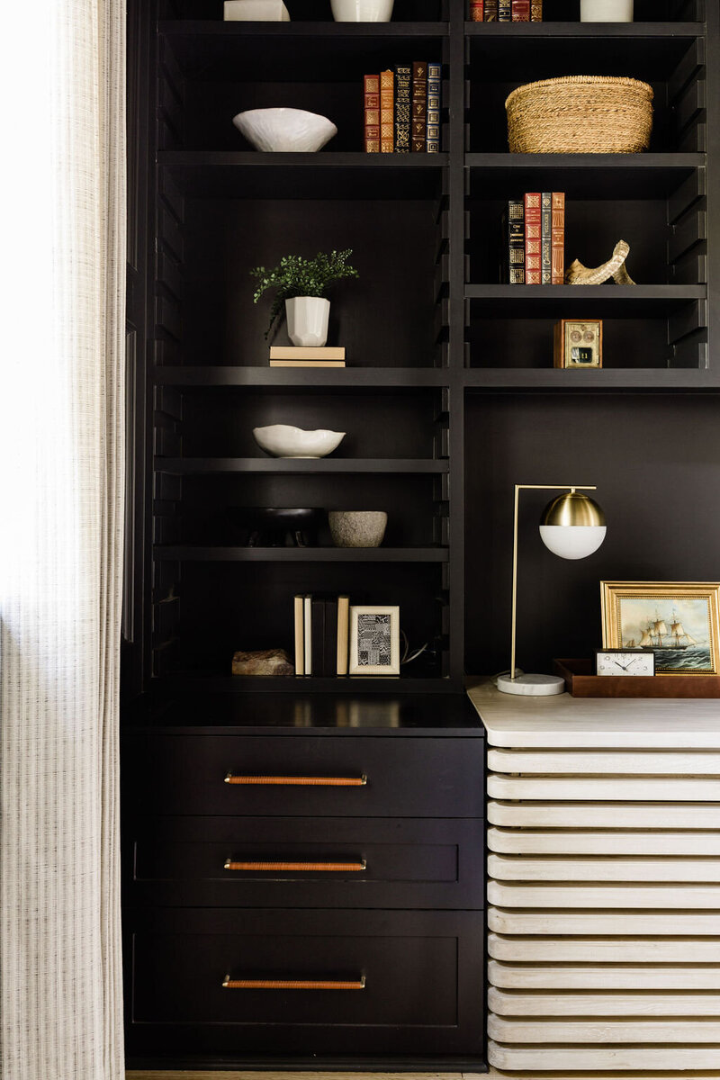 Black french door into home with white brick walls and luxury decor