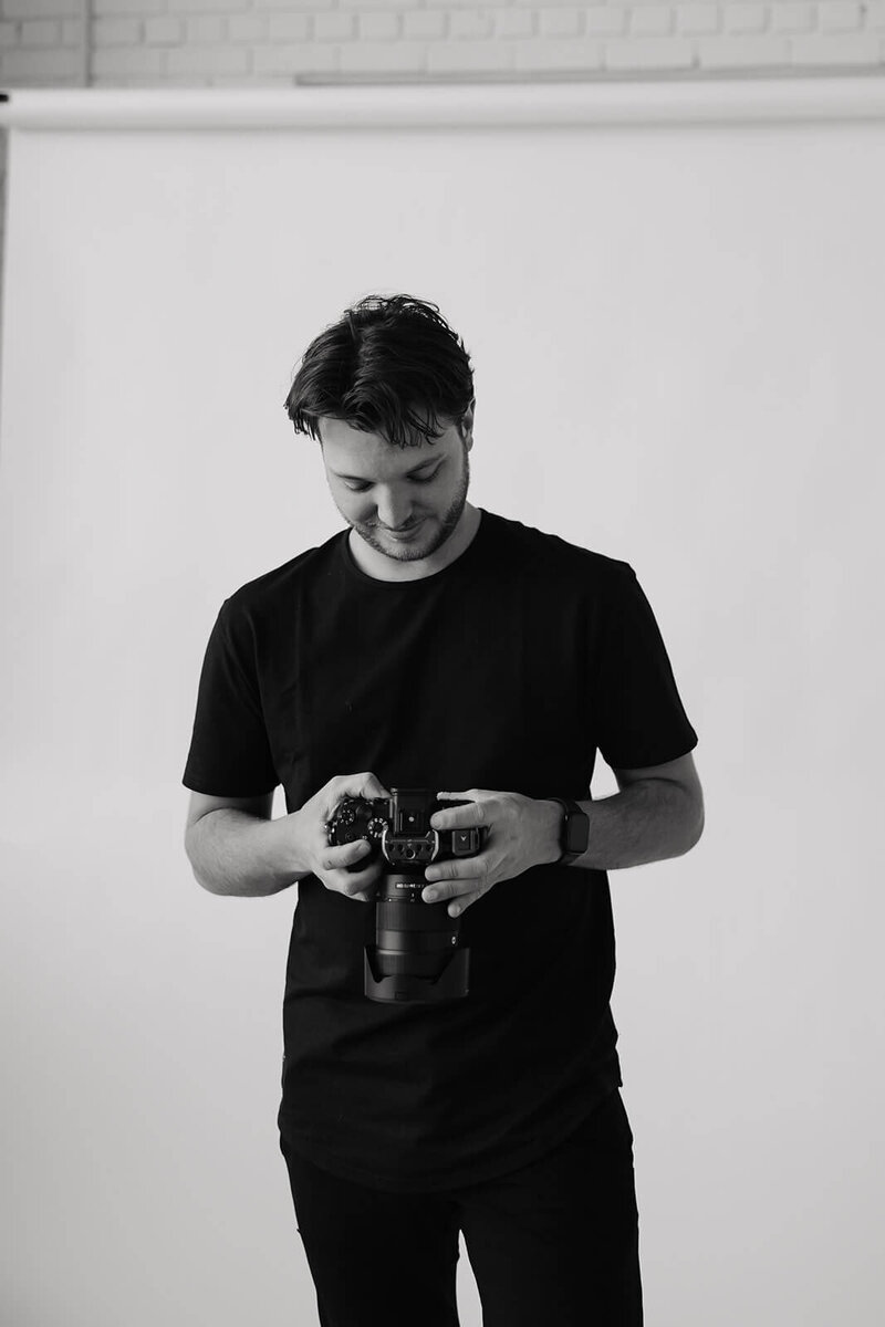Minnesota wedding videographer looks into the viewfinder of his camera