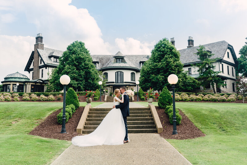 bride and groom hugging in front of steps at Linden Hall wedding venue