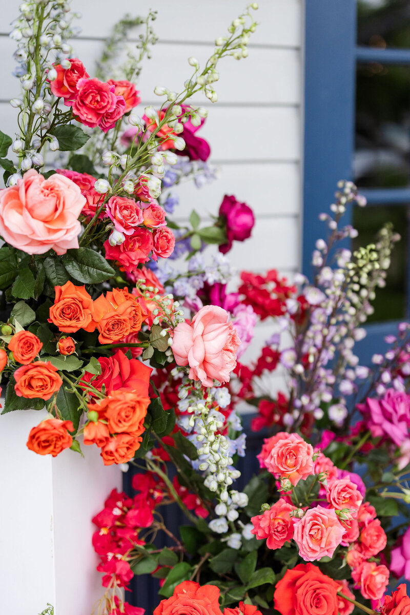 Vibrant floral installation with roses and delphinium, showcasing Bloom Bar’s bold and distinctive corporate floral arrangements.